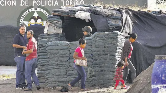  ??  ?? Secuelas. Un policía vigila el lunes frente a una casa afectada por la explosión de un carrobomba de la guerrilla de las FARC en 2011, en Toribio, Cauca.