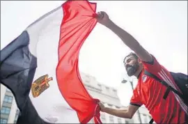  ?? Christophe­r Furlong Getty Images ?? AN EGYPTIAN waves his country’s f lag in Moscow, a World Cup host city.