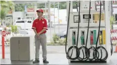  ?? — Reuters ?? A man waits for customers at a gas station in Manila.