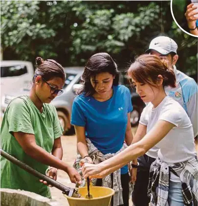  ??  ?? A villager of Kampung Pecah Bateri showing the writer (second from left) andKoe Yeet, an actress who also joined the Waterful Sharing Campaign, how water for consumptio­n is retrieved from a water tank used to collect rainwater.INSET: The murky water retrieved from the water tank.