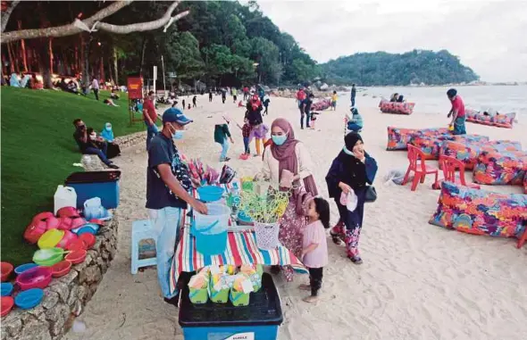  ?? BERNAMA PIC ?? Visitors adhering to the SOP while enjoying themselves at Pantai Teluk Cempedak, Kuantan, yesterday.