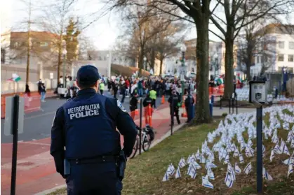  ?? Photograph: Anna Moneymaker/Getty Images ?? A police officer stands nearby a vigil for Aaron Bushnell outside the Israeli embassy on Monday in Washington DC.