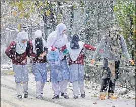  ?? WASEEM ANDRABI/ HT ?? Kashmiri school children walk amid snow in Srinagar on Saturday.