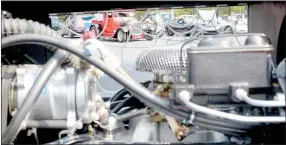  ?? Keith Bryant/The Weekly Vista ?? A line of cars can be seen through a window in Bella Vista resident Eric Gibby’s 1937 Chevrolet pickup’s engine bay, accented with a homemade spiderweb pattern. Gibby said he’s been driving the truck for about eight years after he spent five years building it.