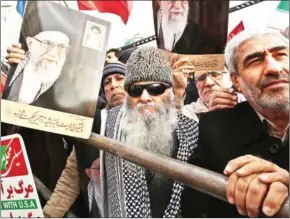  ?? ATTA KENARE/AFP ?? Iranians holding national flags and pictures of Ayatollah Ali Khamenei take part in a pro-government demonstrat­ion in the capital Tehran on Monday.