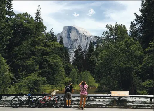  ?? EZRA SHAW – GETTY IMAGES ?? Visitors take pictures of Half Dome on June 11 in Yosemite National Park.