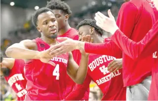  ?? PHOTO BY JULIO CORTEZ/AP ?? TOP TEAM
Houston guard L.J. Cryer (4) is greeted at the bench by teammates during the first half of an NCAA college basketball game against Baylor, Saturday, Feb. 24, 2024, in Waco, Texas.