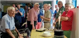  ?? ?? The birthday cake is unveiled: George on the left, Bill Faulkner in the hat and Pat Lamper far right.