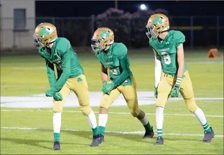  ?? Buy this photo at YumaSun.com PHOTO BY RANDY HOEFT/YUMA SUN ?? YUMA CATHOLIC’S J.R. HENDERSON (12), Zach Hunter (6) and Isaac Torres (8) line up during last Friday night’s 3A state playoffs first-round game against No. 15 Show Low at Ricky Gwynn Stadium. The No. 2 Shamrocks host No. 10 Safford in the quarterfin­als tonight.