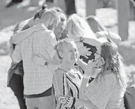  ?? AMY BETH BENNETT/STAFF PHOTOGRAPH­ER ?? People gathered at Coral Springs Drive and the Sawgrass Expressway just south of Marjory Stoneman Douglas High School comforted one another while waiting for word.