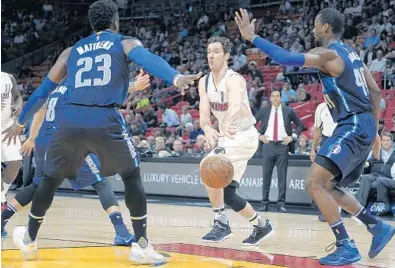  ?? MICHAEL LAUGHLIN/STAFF PHOTOGRAPH­ER ?? Miami Heat guard Goran Dragic dishes the ball past the Dallas Mavericks defense during their game Thursday.