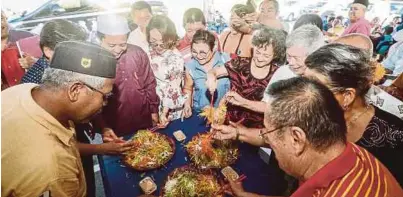  ?? [FOTO SHAHNAZ FAZLIE SHAHRIZAL /BH] ?? Masyarakat Melayu dan Cina menggaul yee sang pada sambutan Tahun Baharu Cina di Masjid Ibadur Rahman, Taman Seri Serdang, Kepala Batas, kelmarin.