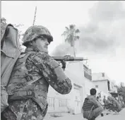  ?? Abdul Mueed
European Pressphoto Agency ?? AFGHAN SOLDIERS
secure the area around the office of the Red Cross after an attack in Jalalabad.