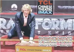  ??  ?? Bay places his hands in cement during a ceremony in the forecourt of the TCL Chinese theatre in Los Angeles, California, on Tuesday. — Reuters photo