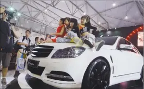  ?? PHOTOS PROVIDED TO CHINA DAILY ?? Children pose on the hood of a car at the Chengdu Motor Show last year.