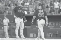  ?? LM OTERO/AP ?? Red Sox pitching coach Dave Bush walks to the mound to check on relief pitcher Ryan Brasier after Brasier gave up two home runs to the Rangers in the sixth inning Sunday in Arlington, Texas.