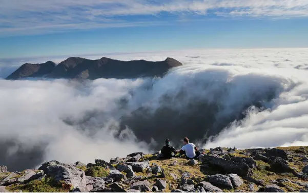  ?? Photo: Valerie O’Sullivan ?? SITTING PRETTY: Lunch above the clouds on the summit of Carrauntoo­hil, on the MacGillycu­ddy’s Reeks, Ireland’s highest mountain range wth Rachel O’Toole and Peter Slattery.