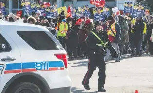  ??  ?? A police officer directs traffic as the large group marches through downtown.