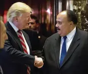  ?? ANDREW HARNIK / ASSOCIATED PRESS 2017 ?? President-elect Donald Trump shakes hands a few days before his inaugurati­on with Martin Luther King III, son of Martin Luther King Jr., at Trump Tower in New York City.