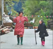  ?? ?? Left: Wu Meifu (left) takes her daughter Liang Zhizhen to plant trees.