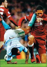  ?? JASON CAIRNDUFF / REUTERS ?? Manchester City's Raheem Sterling tangles with Liverpool's Virgil van Dijk during Tuesday’s UEFA Champions League quarterfin­al second-leg match at Etihad Stadium in Manchester. Liverpool won 2-1 to advance to the semifinals 5-2 on aggregate.