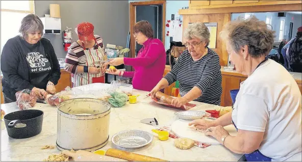  ?? COURTESY OF JONATHAN RILEY ?? With 12 helpers for the fundraiser, volunteers joined an assembly line to get the pies made in time for the sale.