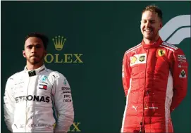  ?? Picture: REUTERS ?? WHO’S SMILING NOW: Sebastian Vettel celebrates his Australian Grand Prix victory as a disappoint­ed Lewis Hamilton looks on in Melbourne yesterday.