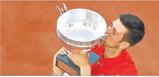  ?? IAN LANGSDON / EFE ?? Novak Djokovic besa el trofeo conquistad­o tras ganar la final de Roland Garros al griego Stefanos Tsitsipas.