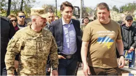  ?? IRPIN MAYOR’S OFFICE VIA AP ?? Canadian Prime Minister Justin Trudeau (center) walks with mayor Oleksandr Markushyn (right) in Irpin, Ukraine, on Sunday. Trudeau made a surprise visit to the severely damaged city on Sunday.