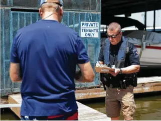  ?? Gustavo Huerta / Staff file photo ?? Deputy Constable Jarrett Rhodes of Montgomery County’s Precinct 1 conducts a safety check for a boater at Stow-A-Way Marina & RV Park at Lake Conroe during the Labor Day weekend.