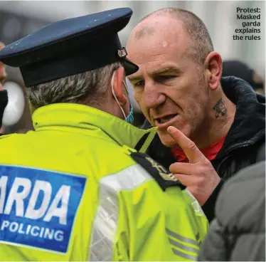  ??  ?? Protest: Masked garda explains the rules