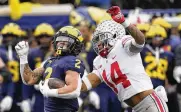  ?? CARLOS OSORIO / AP ?? Michigan running back Blake Corum is chased by Ohio State safety Ronnie Hickman during the second half of the Wolverines’ win last season in Ann Arbor, Michigan. Corum is questionab­le with a knee injury.