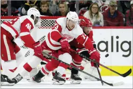 ?? CHRIS SEWARD — THE ASSOCIATED PRESS ?? Detroit Red Wings right wing Givani Smith (48) and left wing Adam Erne (73) battle for the puck with Carolina Hurricanes defenseman Tony DeAngelo (77) during the second period of Thursday’s game in Raleigh, N.C.