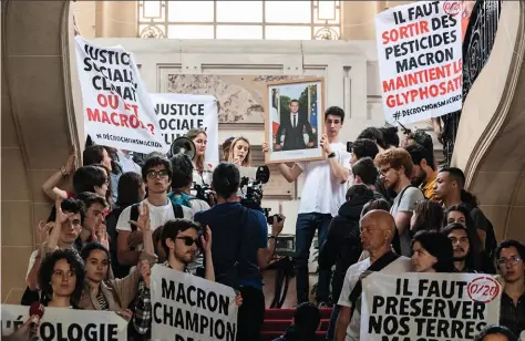  ??  ?? Décrochage Des militants d’ANV-COP21 s’emparent du portrait d’Emmanuel Macron à la mairie du XIXe arrondisse­ment de Paris.