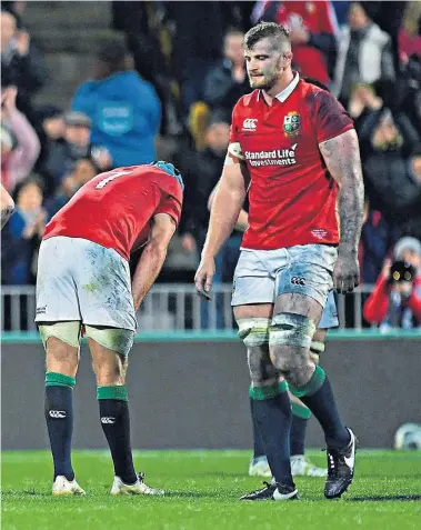  ??  ?? Late collapse: The Lions look dejected after throwing away a 14-point lead to draw against the Hurricanes yesterday