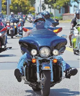  ?? STAFF PHOTOS BY STUART CAHILL ?? SPARKS OF JOY: Riders take to the street, above and below, and check out their rides, bottom, at the Buffalo Soldiers’ 10th annual Buddy Run yesterday. David ‘Megaman’ Bowden, left at left, greets Sam Hopkins at the annual event to raise funds for the...