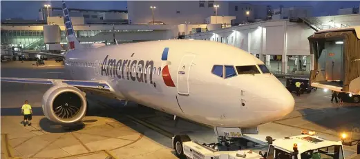  ?? JOE RAEDLE/GETTY IMAGES ?? A grounded American Airlines Boeing 737 Max 8 is towed Wednesday to another location at Miami Internatio­nal Airport.