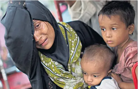  ??  ?? An exhausted Rohingya woman and her children arrive at Kutupalong refugee camp while others, above left, crossed a creek of the Naf river to safety from Burma