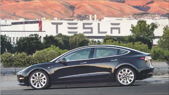  ?? TESLA MOTORS ?? Tesla released the Model 3to rave reviews Friday. The first 30cars were handed over to early supporters and employees, but it will be months until the promised $35,000base model will be available for early reservatio­n holders. With a half-million...