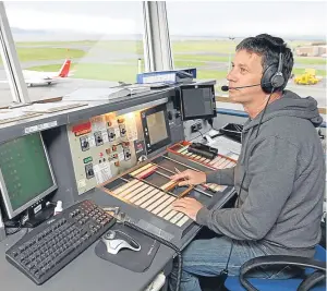 ?? Picture: Gareth Jennings ?? Air traffic controller Alan O’brien keeps an eye on the skies above Dundee.