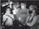  ?? [DOUG HOKE/ THE OKLAHOMAN] ?? Participan­ts hold candles during a candleligh­t vigil Saturday at the Oklahoma Supreme Court building.