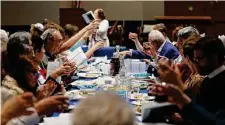  ?? Karen Warren / Staff photograph­er ?? Worshipper­s raise their glasses of grape juice as Rabbi Annie Belford leads the Passover Seder for congregati­on members.