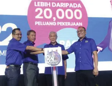  ?? ?? AHMAD Zahid (dua dari kanan) bersama Asyraf Wajdi (kiri) melakukan gimik perasmian ketika majlis pembukaan BN Youth Job Fair 2022 yang berlansung dari 24 hingga 26 Jun di Dewan Tun Razak 3 dan 4, WTC Kuala Lumpur. - Gambar NSTP/MOHAMAD SHAHRIL BADRI SAALI