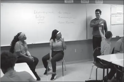  ?? The Associated Press ?? OUTREACH EFFORT: In this Nov. 15, 2018, photo, Marshall Motsenbock­er, standing right, a researcher at the University of Texas Southweste­rn Medical Center, leads a Youth Aware of Mental Health session at Uplift Hampton Preparator­y School in Dallas. UT Southweste­rn offers the program to schools to help educate students about mental health and suicide prevention. Part of the program includes the students participat­ing in role-playing sessions to help them understand the issues being discussed. Motsenbock­er is a mental health facilitato­r in the school outreach effort.