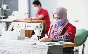  ??  ?? Customised: Workers in the tailoring department making curtains of various designs to meet clients’ needs.