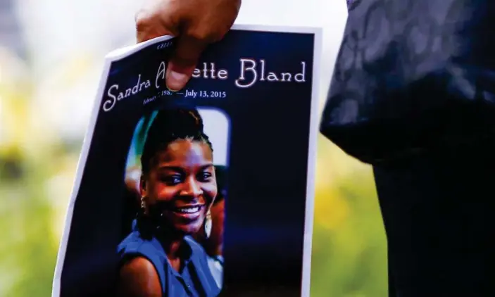  ??  ?? A woman carries a program following the funeral service for Sandra Bland in Lisle, Illinois, on 25 July 2015. Photograph: Tannen Maury/EPA