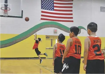  ?? FOTOS CÉSAR NEYOY-BES ?? UN JUGADOR DE los Yuma Suns intenta un enceste en el calentamie­nto previo al juego inaugural de la Liga Juvenil de Basquetbol de Somerton, en el gimnasio de la escuela secundaria local, el lunes.