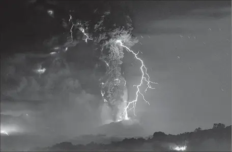  ?? Martin Bernetti
AFP/Getty Images ?? IN SOUTHERN CHILE, a lightning bolt illuminate­s the plume of ash spewing from the Calbuco volcano. Nearby communitie­s were covered with a layer of ash several inches thick. About 5,000 residents were evacuated from a 13-mile-radius zone.