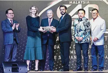  ??  ?? Prestigous award: Naza Automotive Manufactur­ing CEO Laurence Noel (second from left) and Samson with the Car of the Year 2018 award. With them are (from left) MAI CEO Datuk Madani Sahari, Prime Minister Tun Dr Mahathir Mohamad, Internatio­nal Trade and Industry Minister Darell Leiking and Malaysia Car of the Year 2018 panel of judges chairman Yamin Vong.