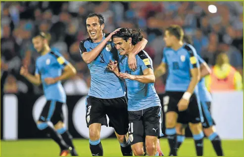  ?? AFP ?? LIDERES. El capitán Godín abraza a Cavani, autor de dos goles ante Venezuela. El equipo terminó con puntaje ideal como local.